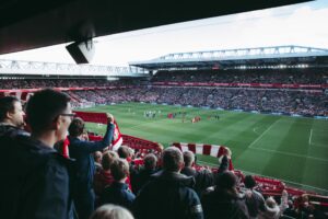 Excited Liverpool fans celebrate in the stadium, exemplifying the passion behind the team's use of data analytics in football for strategic success.